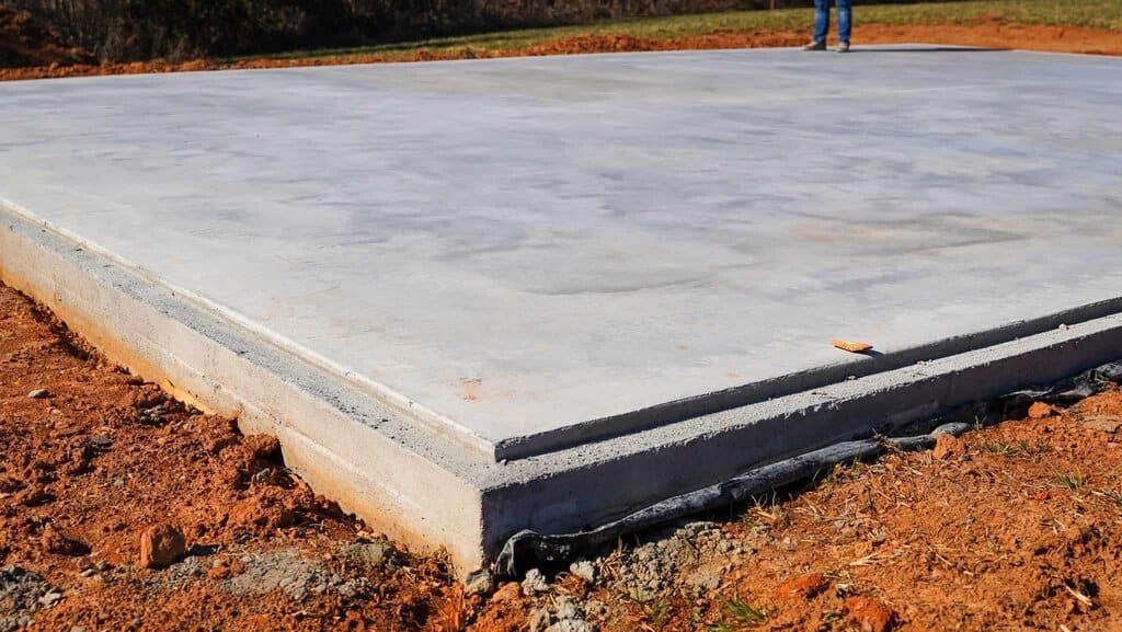 Thick reinforced concrete slab with turned-down edge beam for a metal building